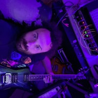 a man in a purple room with a guitar